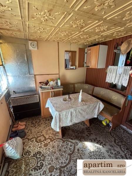 Ház belső antik mintás asztallal és fa részletekkel a kertekben.