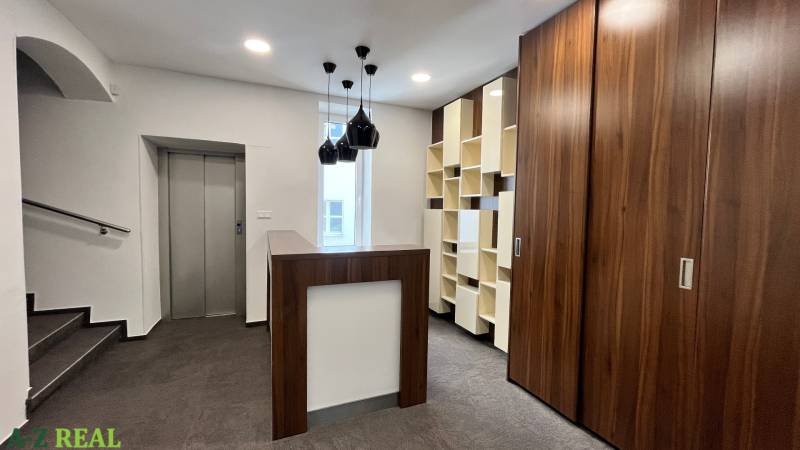 Irodák fa elemekkel, lifttel, modern világítással és sötét padlóval fa dekorációval.