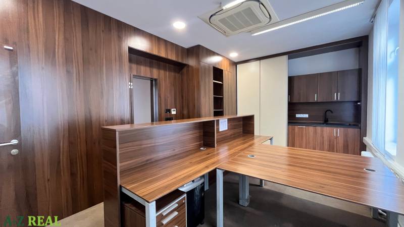 Iroda fa dekorral ellátott padlóval és konyhasarokkal, széles fa pult.