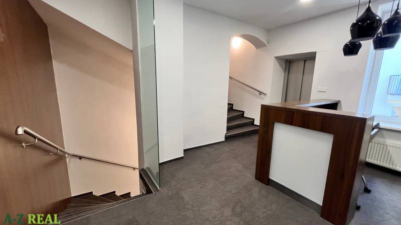 Irodák recepcióval, lépcsőház, fa dekorációjú padló.