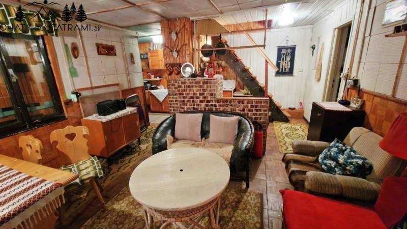 Házikó rusztikus bútorokkal és kényelmes ülőhellyel, fa dekorációjú padlóval.