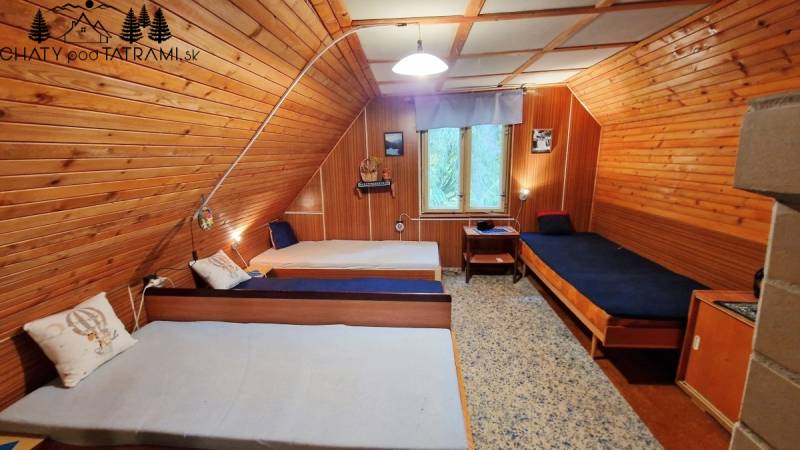 Faház belső tér három egyszemélyes ággyal és tájképpel.