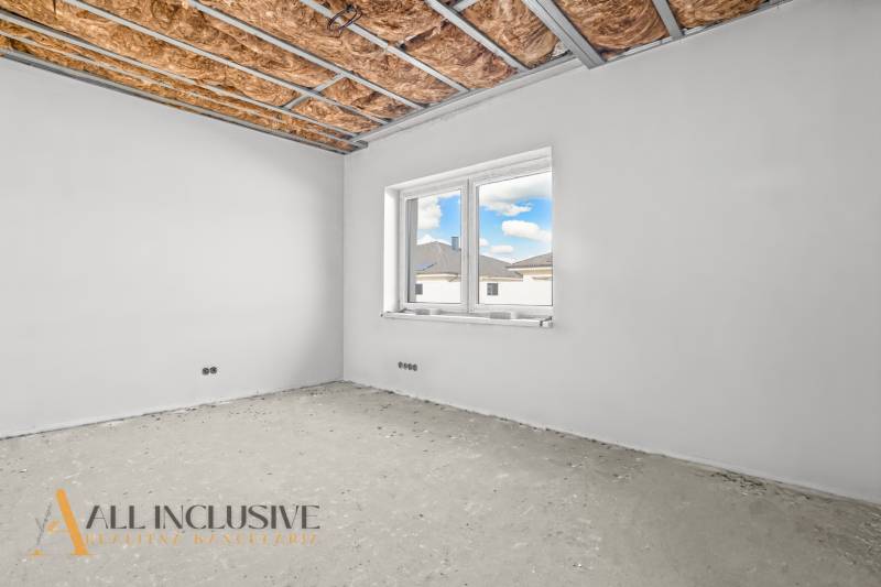 Surova szoba egy családi házban ablakkal és szigetelt mennyezettel.