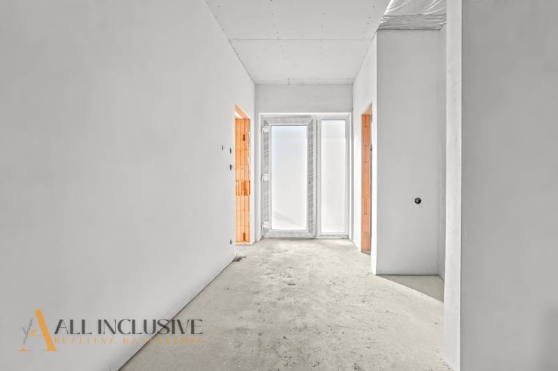 Világos folyosó egy családi házban két nyitott ajtóval és matt üveggel.