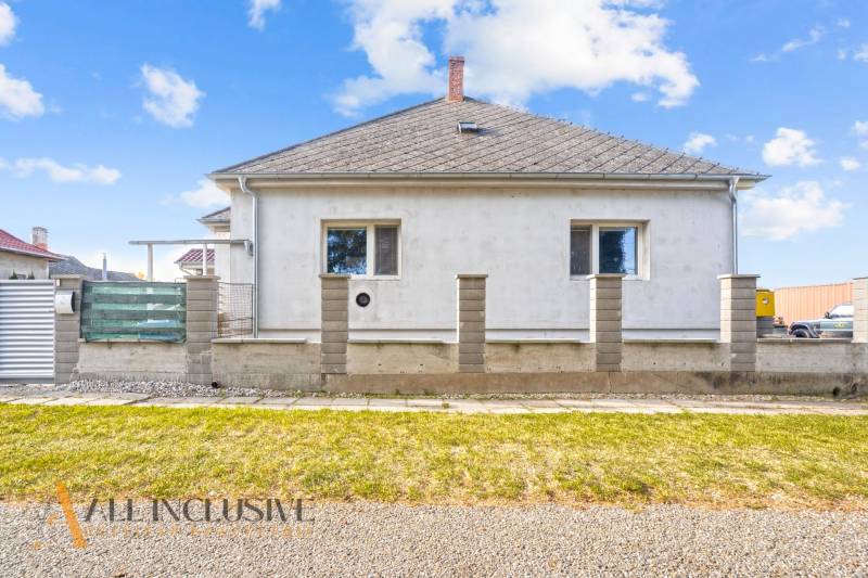 Családi ház Nagykosihán egyszerű homlokzattal és rendezett külső térrel.