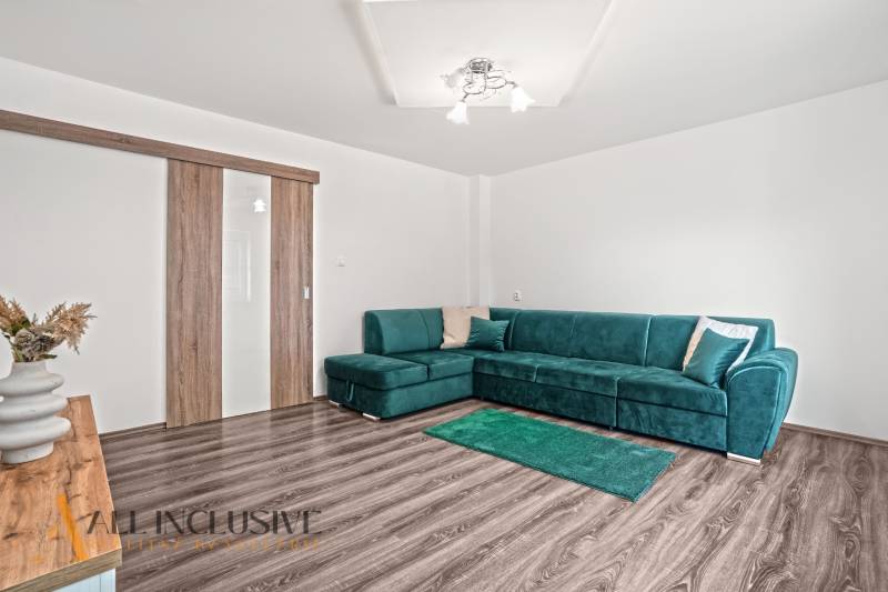 Nappali egy családi házban kanapéval és fa dekorációjú padlóval.