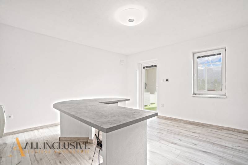 Családi ház belső tere pulttal és fa dekorációjú padlóval.