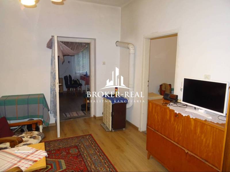 Nappali egy családi házban szőnyeggel és fa dekorációjú padlóval.