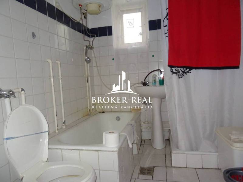 Fürdőszoba káddal és fehér csempékkel egy családi házban.