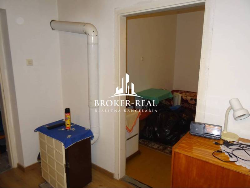 Családi ház belső tere fűtőtesttel, bútorokkal és fa dekorációjú padlóval.