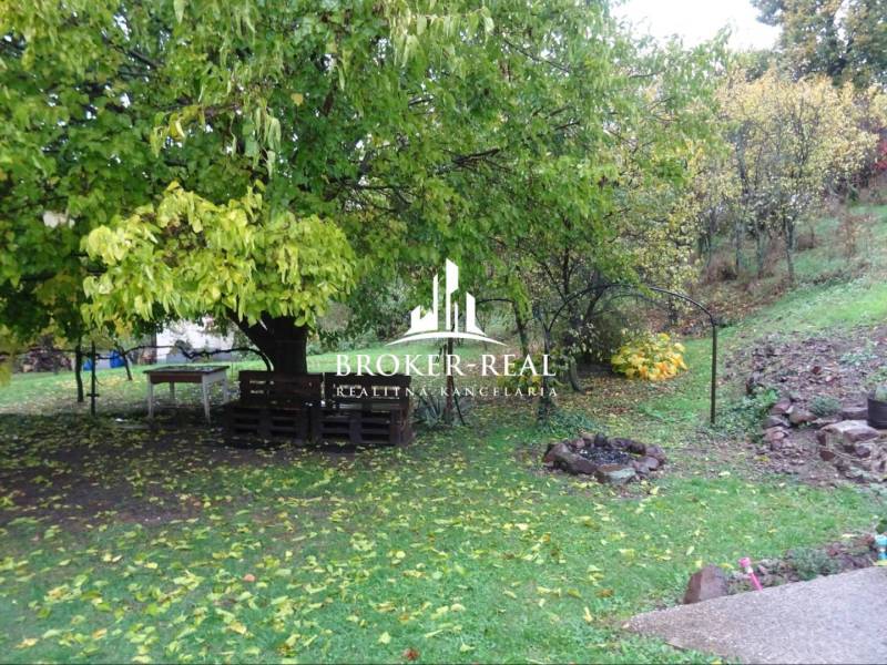 Családi ház kertje Fonyban, raklapokból készült ülőgarnitúrával és tűzrakóhellyel.