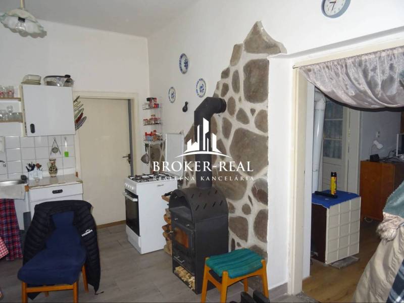 Konyha családi házban tűzhellyel, kemencével és kőburkolattal a falnál.