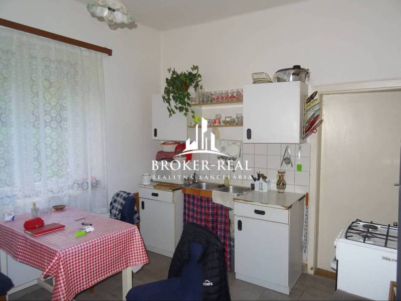 Konyha családi házban klasszikus berendezéssel, függönyök, fehér konyhabútor.