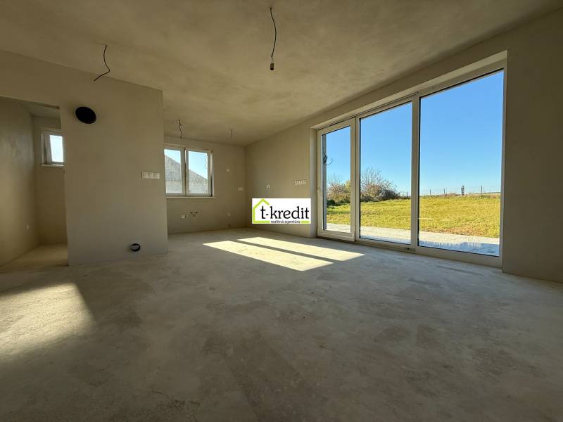 Tágas családi ház belső tér nagy ablakokkal és kilátással a kertre.