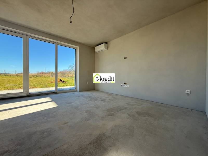 Tágas szoba egy családi házban nagy ablakokkal és kilátással a kertre.