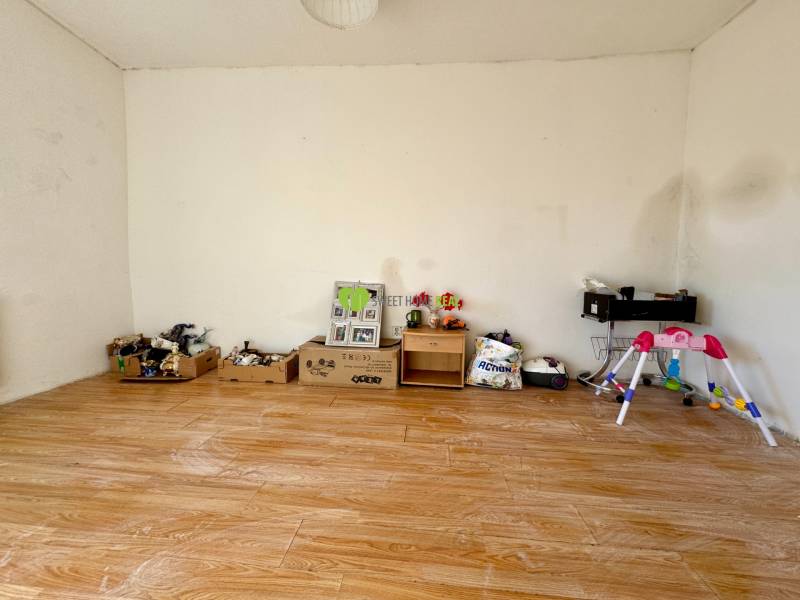 Egy szoba családi házban, játékokkal teli falakkal és fa dekorációjú padlóval.