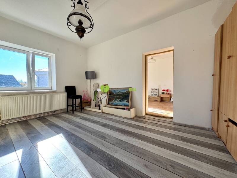 Szoba egy családi házban lámpával, képpel és fa dekorációjú padlóval.