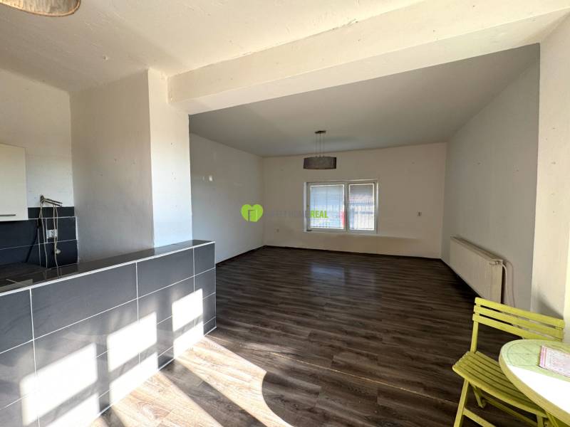 Családi ház belső tere tágas helyiséggel, fa dekorációjú padlóval és étkező sarokkal.