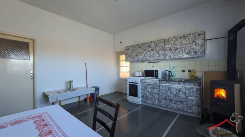 Konyha családi házban kályhával és konyhapulttal, fa dekorációjú padlóval.