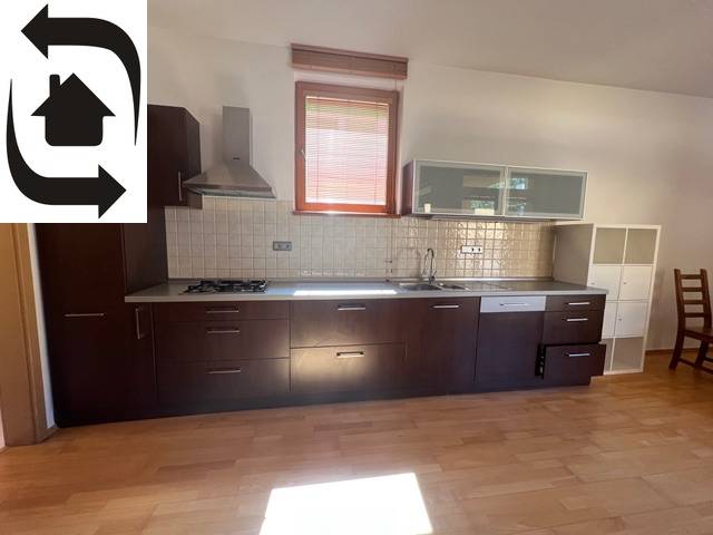 Konyha sötét szekrényekkel és készülékekkel a Moszkva utcai háromszobás lakásban.