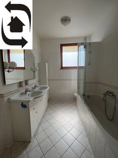 Fürdőszoba világos csempékkel, dupla mosdóval és káddal egy négy szobás lakásban.