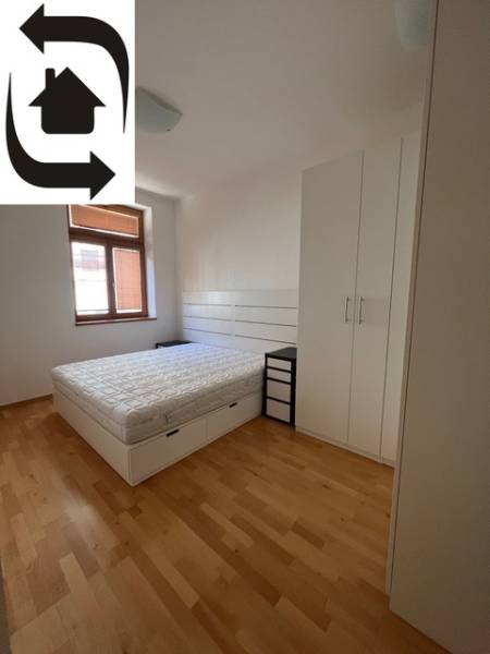 Hálószoba világos bútorokkal és fa dekorációjú padlóval egy 4 szobás lakásban.