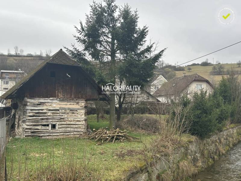 Faház a patak mellett, fákkal körülvéve, fű a telken - vidéki élet.