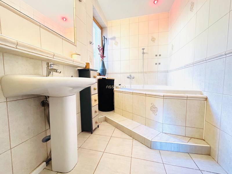 Fürdőszoba káddal, mosdóval és csempével egy kétszobás lakásban.