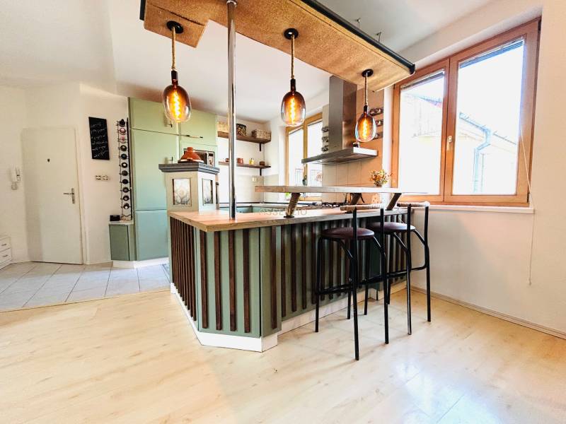 Konyha egy kétszobás lakásban bárpulttal és fa dekoros padlóval.