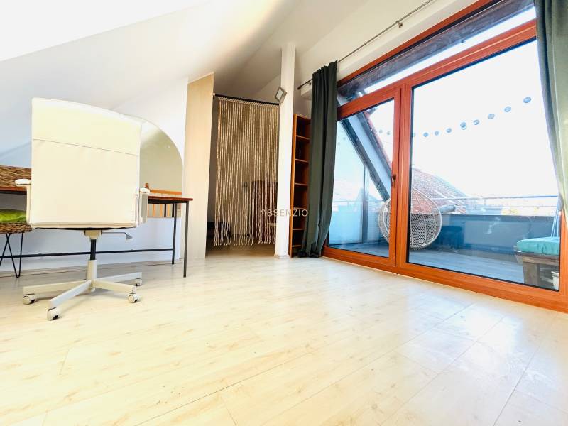 Dolgozószoba egy kétszobás lakásban, fa dekoros padlóval és erkélyajtóval.