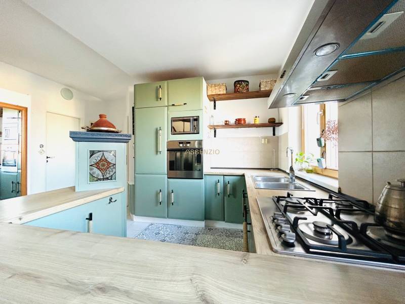 Konyha egy kétszobás lakásban gáztűzhellyel és díszített szekrényekkel.