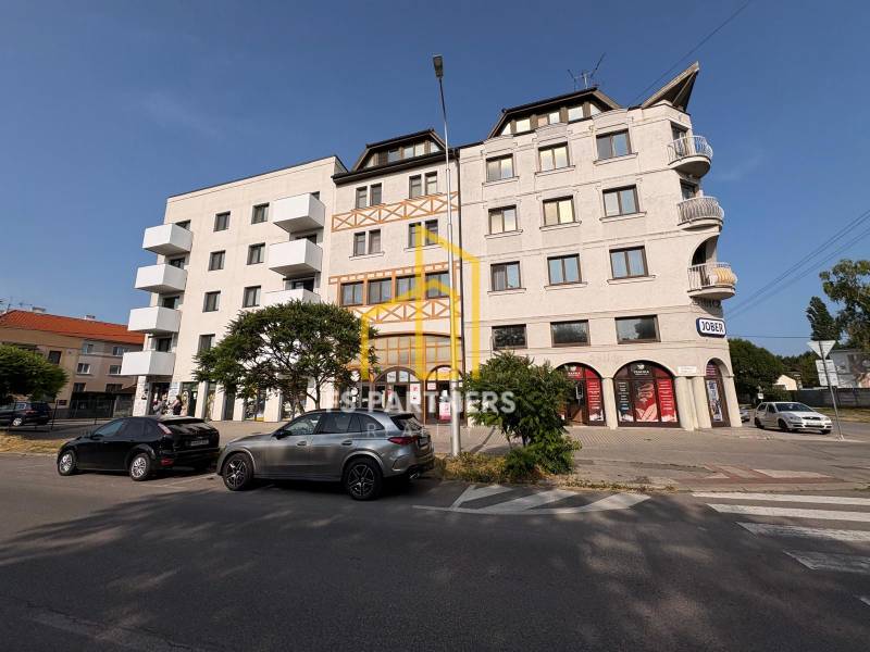 Épület a Komáromi Petőfi utcában, 4 szobás lakásokkal és üzlethelyiségekkel.