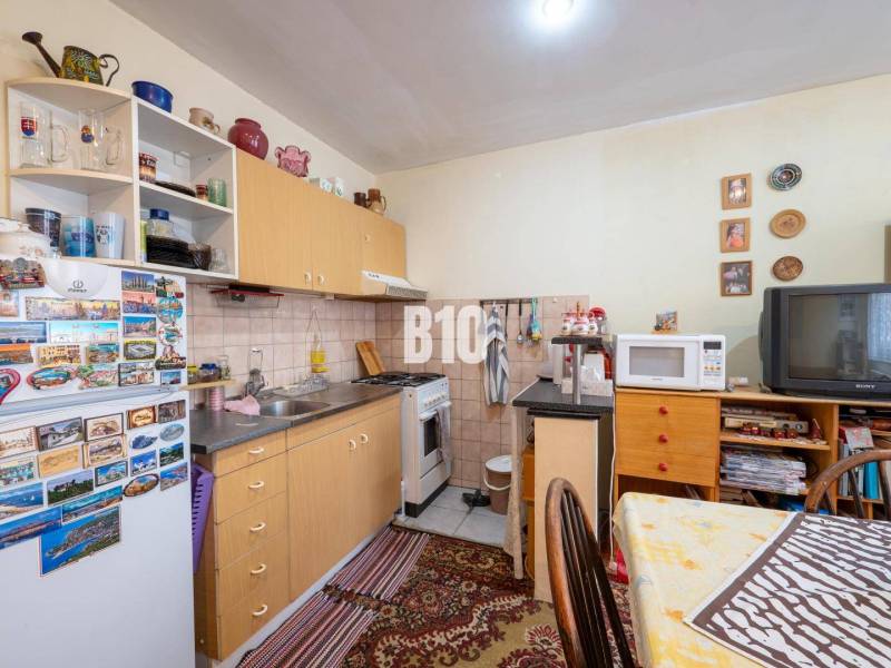 Konyha egy kétszobás lakásban konyhabútorral, háztartási gépekkel és dekorációs tárgyakkal.