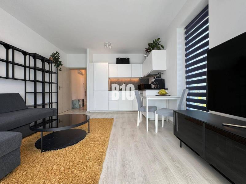 Nappali sarokkanapéval és fa dekor padlóval egy kétszobás lakásban.