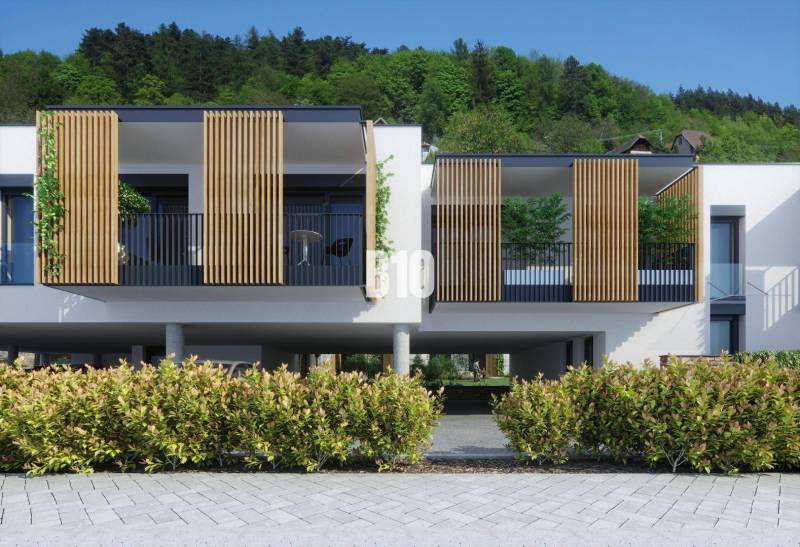 Egy modern épület fa elemekkel a zsolnai Alsó utcában, zölddel körülvéve.