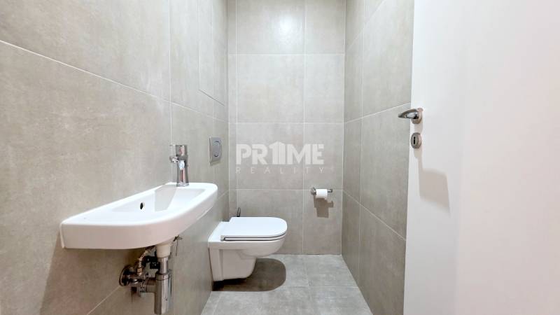 Fürdőszoba egy kétszobás lakásban WC-vel, mosdóval és semleges árnyalatú csempékkel.