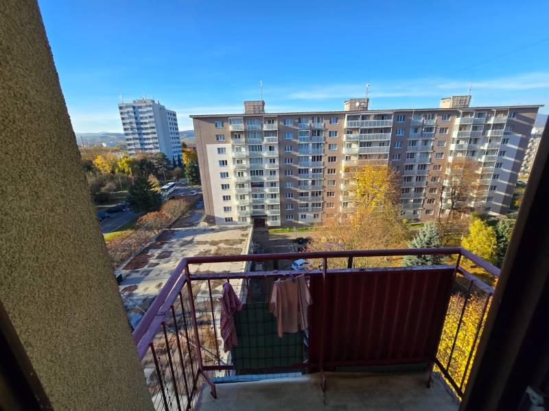 Kilátás egy kétszobás lakás erkélyéről az SNP utcán, Új-Dubnicán, kilátással a panelházakra.