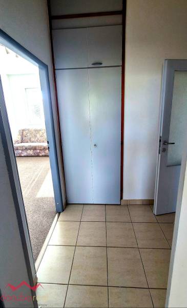 Csempézett folyosó a háromszobás lakásban a szőnyeges szoba mellett.