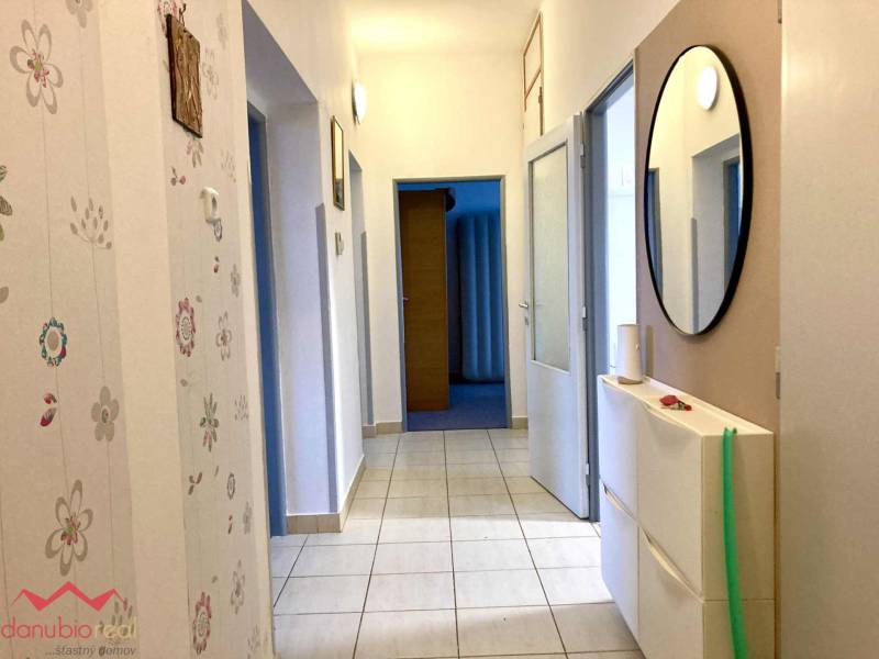 Folyosó egy 3 szobás lakásban virágos tapétával és tükörrel a falon.