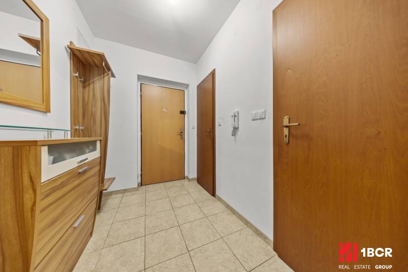 Előszoba egy kétszobás lakásban fa bútorokkal és csempével.