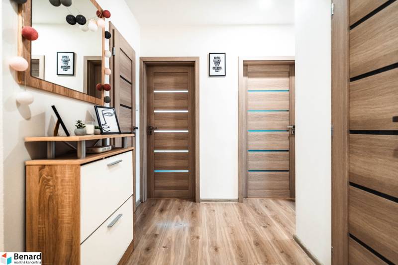 2 szobás lakás belső tere fa dekor padlóval, ajtókkal és dekorációkkal.