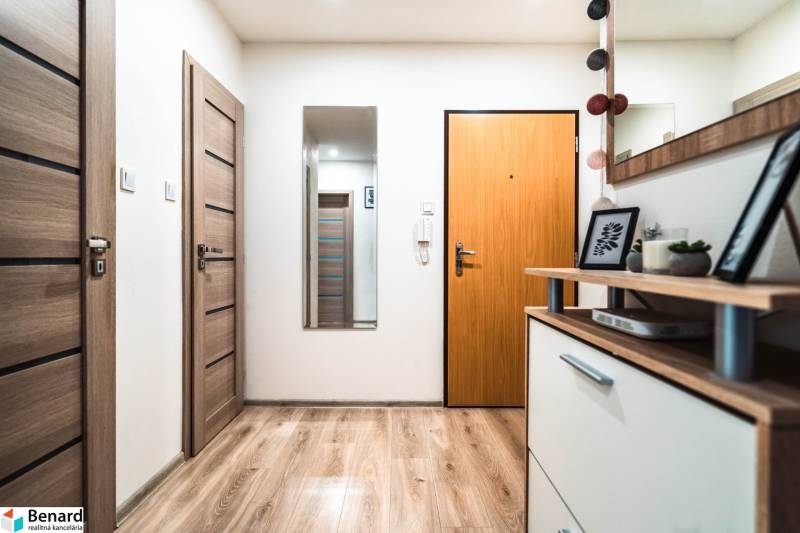 Folyosó egy 2 szobás lakásban fa dekoros padlóval és dekorációkkal.