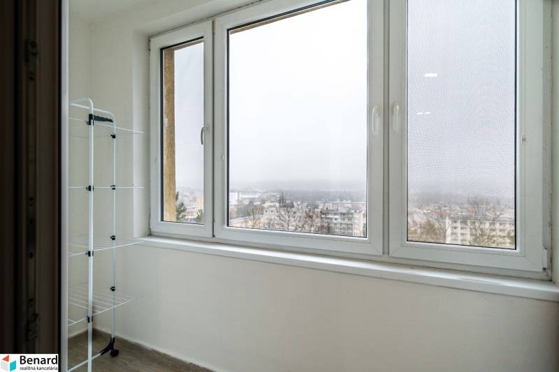 Erkély kilátással egy 2 szobás lakásban, ruhaszárító állvány, ködös város.