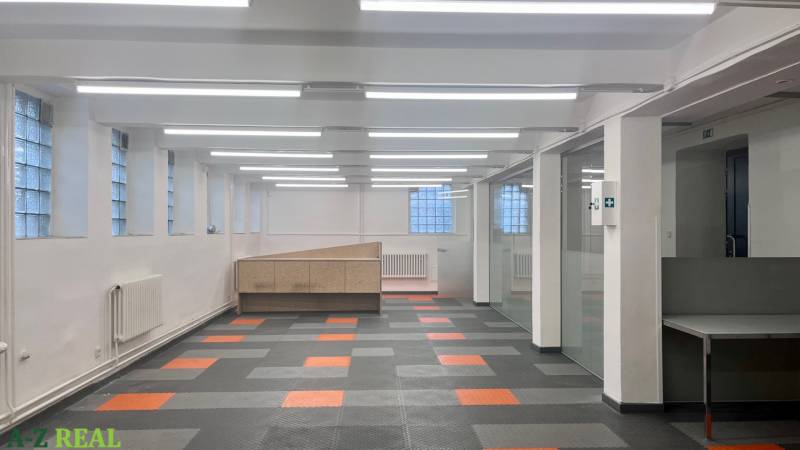 Színes padlóval és üvegfalakkal rendelkező üzlethelyiség, irodának vagy üzlethelyiségnek alkalmas.