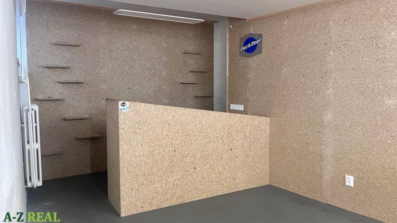 Kereskedelmi helyiségek belső tere fa dekorációval és falra szerelt polcokkal.