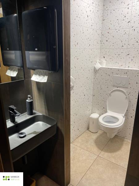 Mosdó a vendéglátóhelyiségekben mosdókagylóval, tükörrel és terrazzo burkolatokkal.