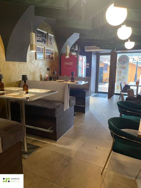 Vendéglátóhely belső tér kényelmes ülőhelyekkel és dekoratív lámpákkal.