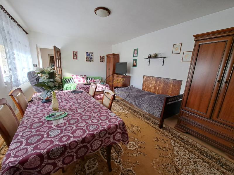 Nappali egy családi házban bútorokkal, étkezőasztallal és dekorációkkal.