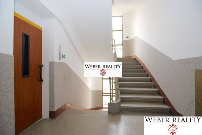 Folyosó lifttel és lépcsőházzal, amely a kétszobás lakás emeletére vezet.