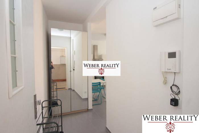 Folyosó egy 2 szobás lakásban fogassal, tükörrel és csempével.